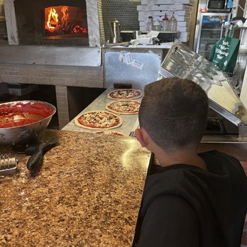 Buonocores Brick Oven Pizza - a young boy making pizza - Pizza Near Me - Haledon, New Jersey Buonocores Brick Oven Pizza - a young boy making pizza - Pizza Near Me - Haledon, New Jersey