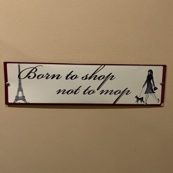 Springers - Sign in the bathroom - A rectangular sign with the phrase "Born to shop not to mop" in cursive font, featuring illustrations of the Eiffel Tower and a woman walking a dog. - American Near Me - Stoughton, Wisconsin