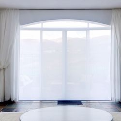Decor 8 Interiors - Custom-made cornice with eyebrow arch, waterfall side panels in bishop style, and a motorized solar shade
