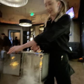 Sullivan's Steakhouse - Kenzie serving up a Smoked Rosemary & Orange Old Fashioned ($15)...sorry it's blurry. - Steakhouses Near Me - Palm Desert, California Sullivan's Steakhouse - Kenzie serving up a Smoked Rosemary & Orange Old Fashioned ($15)...sorry it's blurry. - Steakhouses Near Me - Palm Desert, California