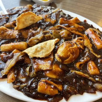 Korean Noodle House - This is Jjajjang Ddukbokki.  It's rice cake with fish cake, lettuce, eggs, fried dumpling in delicious Jjajjang sauce.  Yummy!!!  :) - Korean Near Me - Flushing, New York