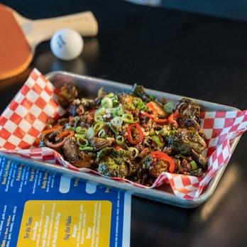 Almost Friday Sporting Club - a tray of food and ping pong paddles - New American Near Me - Nashville, Tennessee