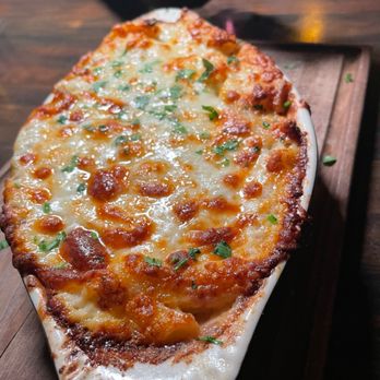 Pharaohs Palace - a cheesy pizza on a wooden board - Mediterranean Near Me - Johns Creek, Georgia