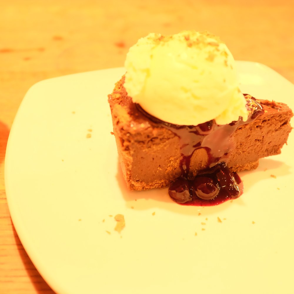 Giraffe - Chocolate tart with cherries in sauce and ice cream - Food Near Me - London Gatwick, WSX Giraffe - Chocolate tart with cherries in sauce and ice cream - Food Near Me - London Gatwick, WSX