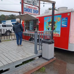 a woman walking towards a food truck a woman walking towards a food truck