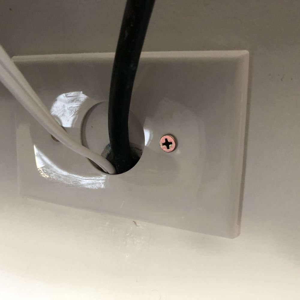 Modtech Design - Extension cord (white) run directly behind wall. This is not up to code and had to be removed. The plate was also installed crooked. - Home Theatre Installation Near Me Modtech Design - Extension cord (white) run directly behind wall. This is not up to code and had to be removed. The plate was also installed crooked. - Home Theatre Installation Near Me