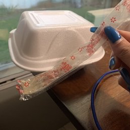 a hand holding a plastic container with a plastic lid a hand holding a plastic container with a plastic lid