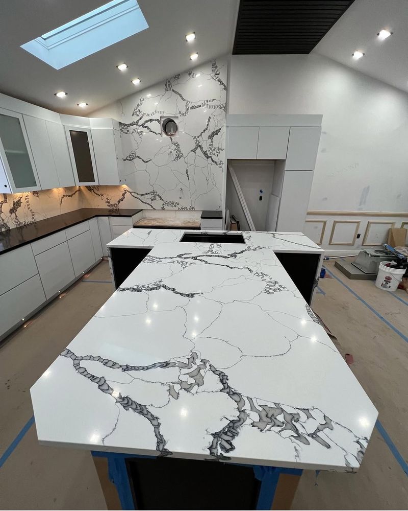 Master stone fabricator at Luxury Granite Design Sterling Heights working on a large granite slab with precision tools in their fabrication facility