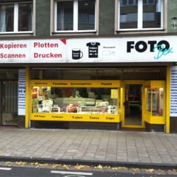 Digitaldruck Scharf - Foto Box - Morgens bevor der Laden öffnet. Wenn geöffnet ist, steht ein Postkartenständer vor dem Laden.