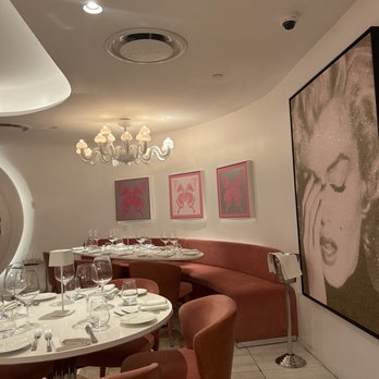 Sofia Design District - a dining room with a large painting on the wall - Italian Near Me - Miami, Florida Sofia Design District - a dining room with a large painting on the wall - Italian Near Me - Miami, Florida