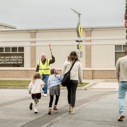 Antioch - Family crossing a street downtown as crossing guard stops traffic.