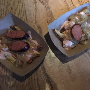 Wursthaus - Spicy polish on the left and smoked brat on the right both with drunken fries - Pubs Near Me - Santa Ana, California