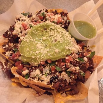Tacos El Richi - a plate of nachos with guacamole - Tacos Near Me