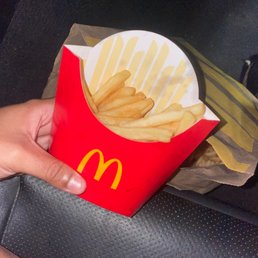 a hand holding a box of french fries a hand holding a box of french fries