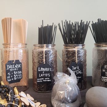 Cloverleaf Nook - Incense. - Display table with four glass jars containing incense sticks labeled as 'Incense Sticks,' 'Libraries & Lattes,' 'Dark Crystal,' and 'Fall in the Shire.' - Gift Shops Near Me - Culpeper, Virginia