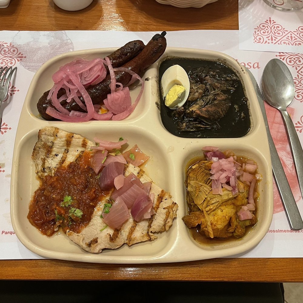 combo plate with longaniza, relleno negro, conchinita, and poc-chuc combo plate with longaniza, relleno negro, conchinita, and poc-chuc