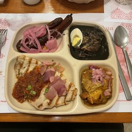 combo plate with longaniza, relleno negro, conchinita, and poc-chuc combo plate with longaniza, relleno negro, conchinita, and poc-chuc