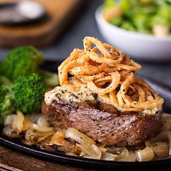 Logan's Roadhouse - Onion Brewski Sirloin: Our 8-ounce Top Sirloin stacked on beer-braised onions & topped w/ garlic butter & crispy onions.