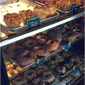 PVDonuts - display case full and even more trays full behind the counter - Donuts Near Me - Providence, Rhode Island