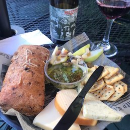 a plate of cheese, bread, crackers, and a glass of wine a plate of cheese, bread, crackers, and a glass of wine