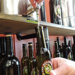 Filling a bottle with fresh olive oil