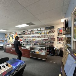 LIL Games & Collectibles - Pictured is a large selection of sealed Pokemon and MTG products on the shelves