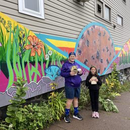 Kids with their goodies in front of the bakery mural.