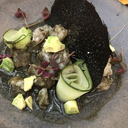 Marinated sea bass with avocado and cucumber in a black aguachile (sp?) sauce. Marinated sea bass with avocado and cucumber in a black aguachile (sp?) sauce.