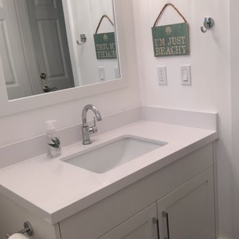 Versatile Construction - a bathroom with a sink and mirror - General Contractors Near Me