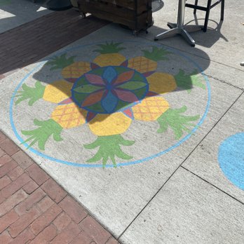 Artists Row - A sidewalk features a painted design with pineapples and floral patterns in yellow, green, blue, and orange colors. - Public Art Near Me - Salem, Massachusetts