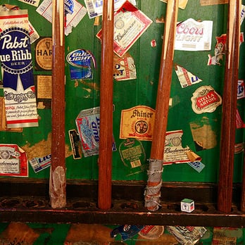 Midtown Billiards - a green wall with stickers on it - Dive Bars Near Me - Little Rock, Arkansas