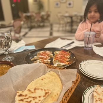 Kabul House - a little girl sitting at a table with food - Afghan Near Me - Evanston, Illinois