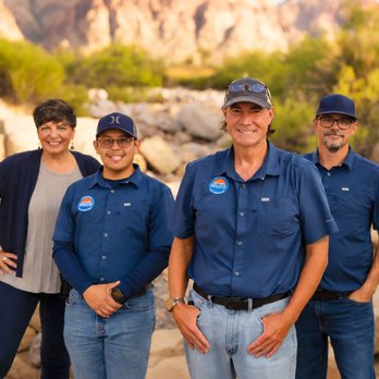 Absolute Home Inspections - A team of four people standing outdoors in front of a rocky desert canyon landscape, with three wearing matching blue branded... - Home Inspectors Near Me Absolute Home Inspections - A team of four people standing outdoors in front of a rocky desert canyon landscape, with three wearing matching blue branded... - Home Inspectors Near Me