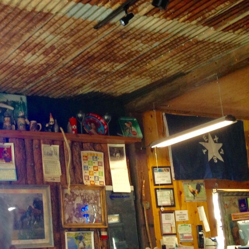 Rooster's - Rusty tin ceiling and log walls complete with bark makes for a look of yesteryear! - Tex-Mex Near Me - Vega, Texas