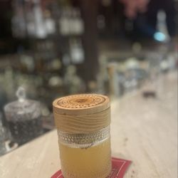 Liam's Den & Bubble Bar - Lions Courage that was a smoked cocktail made with bourbon, ginger, and peach.