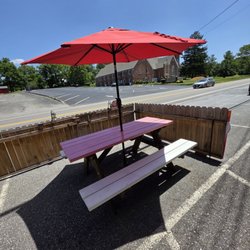 JT’s IceCream Shop - The fenced in patio with one picnic table and red umbrella.