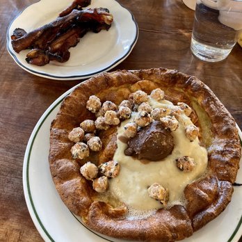 Milktooth - Pawpaw pudding Dutch Baby pancake with crispy bacon. - Breakfast & Brunch Near Me - Indianapolis, Indiana Milktooth - Pawpaw pudding Dutch Baby pancake with crispy bacon. - Breakfast & Brunch Near Me - Indianapolis, Indiana