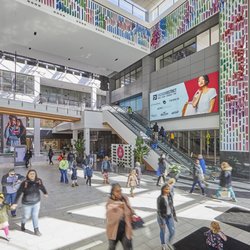 Fashion District Philadelphia - Shoppers gather near the escalators and digital displays inside Fashion District Philadelphia.