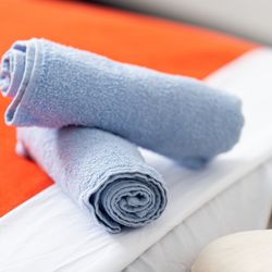 Prepared for Relaxation: Neatly rolled towels await Massage by Monique's guests, promising comfort and care.