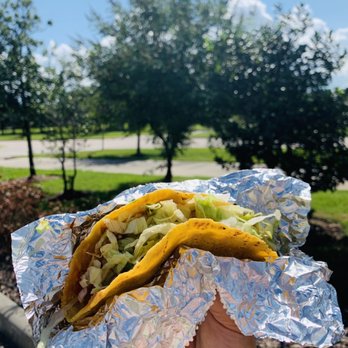 El Pollo Loco - a hand holding a taco - Fast Food Near Me - Pearland, Texas