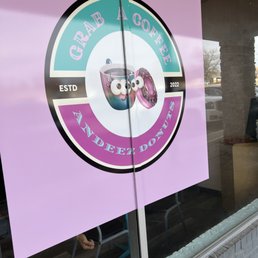 a sign in the window of a donut shop a sign in the window of a donut shop