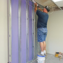Building an independent wall next to a common wall for soundproofing. The new wall goes up past the hung ceiling, to the actual ceiling.