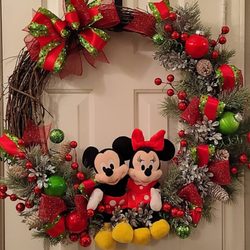 Mickey and minnie sitting on a wreath