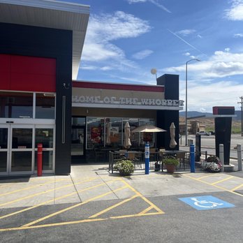 Burger King - Entrance - Exterior view of Burger King in Beaver, UT, showing the storefront, outdoor seating area with umbrellas, and parking spaces including a handicapped spot. - Burgers Near Me - Beaver, Utah