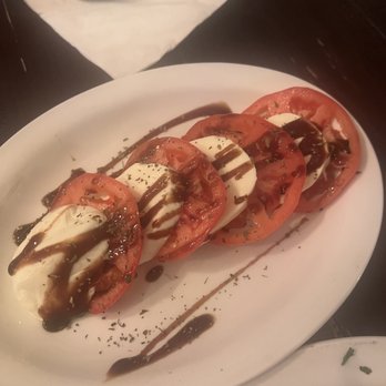 Tomanetti's Pizza - a tomato and mozzarella on a white plate - Pizza Near Me - Oakland, Maryland Tomanetti's Pizza - a tomato and mozzarella on a white plate - Pizza Near Me - Oakland, Maryland