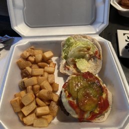a takeout box with a sandwich and fries