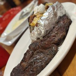 Chatitas Mexican Restaurant - Ribeye w/loaded baked potato ... Queso Fundido in the background.