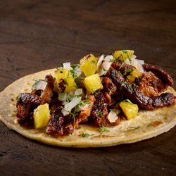 Taco Bamba - Spiced Pork and Pineapple, al pastor taco served on corn tortillas and topped with sliced onions and cilantro found on the me...