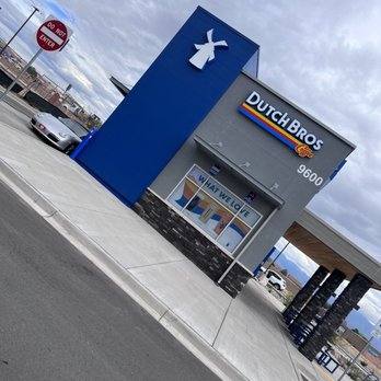 Dutch Bros Coffee - A Dutch Bros Coffee location in Albuquerque, NM features a blue and gray building with the Dutch Bros logo and branding, and a drive-thru window. - Coffee & Tea Near Me - Albuquerque, New Mexico