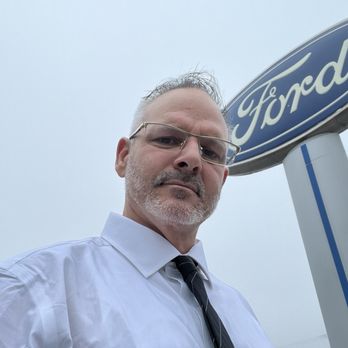 Newport Ford - Shawn Helmick with ford sign in back - Car Dealers Near Me - Newport, Oregon Newport Ford - Shawn Helmick with ford sign in back - Car Dealers Near Me - Newport, Oregon